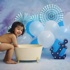 A simple and sweet bathtub session with a blue nautical theme. The anchor prop and blue balloons create a fun, sky-and-sea vibe for this little splasher.