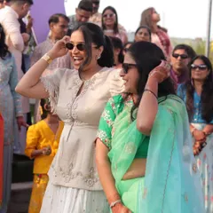 Sharing a laugh with a guest during a daytime wedding event. It's these small, personal interactions that make a big difference in making everyone feel comfortable and included.