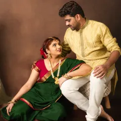 A classic portrait of a couple in traditional attire. The rich colors of the green saree and yellow kurta create a vibrant and culturally rich image.