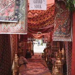 The entrance to a Dubai-inspired 'Grand Souk' Mehendi, where guests are welcomed through a tunnel of layered carpets, rich textiles, and glowing brass lanterns.