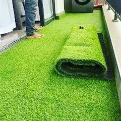 My team rolling out a 25mm artificial grass carpet during an installation in Gurugram. I ensure the turf is laid flat and cut precisely to fit the specific dimensions of your balcony or patio.