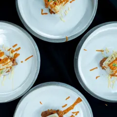 A stunning top-down shot of four plates of our artfully crafted ratatouille, just before being served. The presentation is as important as the taste, designed to be a feast for the eyes as well as the palate.