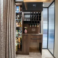 A discreet and stylish bar unit tucked away in the corner of the living room. The dark wood finish and built-in wine rack make it a functional and elegant addition to the space.