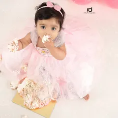 The best part of a cake smash is getting to eat the cake. This overhead shot captures the pure joy and delicious mess of a first birthday celebration.