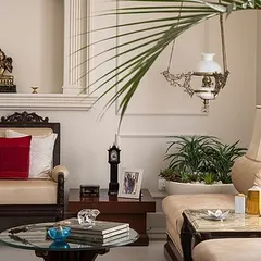 A detail shot from the Kaira residence, highlighting the neo-classical elements and neutral color palette. The space is adorned with traditional carved furniture and carefully selected decor to evoke a feeling of calm and tranquility.