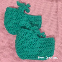 A pair of soft, hand-crocheted teal baby booties with simple tie closures to keep them snug on little feet.