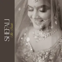 A serene black and white portrait of the bride, her gentle smile captured under the soft light of her veil. This timeless shot focuses purely on her emotion and beauty.