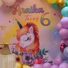 The centerpiece of our unicorn theme, featuring a custom backdrop with Anaika's name and age. The soft colors and charming unicorn illustration set a magical tone for the entire event.