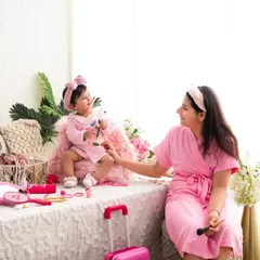The giggles continue. This wider shot of the mother-daughter spa day shows the full setup, complete with a mini suitcase and accessories, designed for imaginative play.