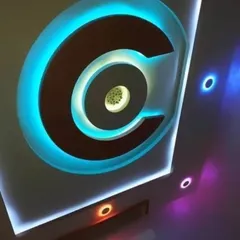 A creative PVC design featuring a large 'C' shape with bright cyan backlighting. The different colored spotlights on the side add a playful touch.