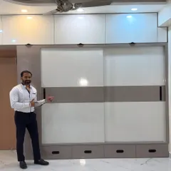 Here I am with a completed sliding wardrobe. This design features a two-tone finish with a central band, creating a modern look. The floor-to-ceiling construction with integrated lofts ensures you get the maximum possible storage from the wall space.