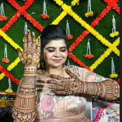 A happy client posing with her intricate Karva Chauth mehndi.