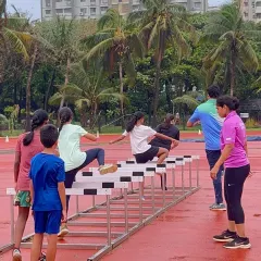I provide hands-on coaching for all my athletes. Here, a coach carefully guides young hurdlers, correcting their form to ensure they learn the proper technique safely and effectively.