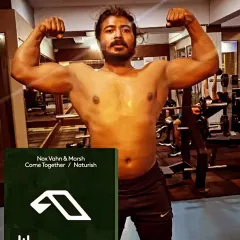 A classic front double biceps pose in the gym. This is a fundamental pose for any bodybuilder, showcasing arm size, chest fullness, and shoulder width.