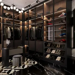 The walk-in wardrobe section features custom glass-fronted cabinetry with integrated lighting, showcasing the collection like a luxury boutique. The geometric black and white floor pattern continues, tying the spaces together.
