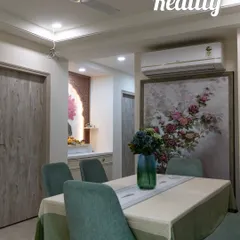 Visualization vs. Reality: A dining area. The final space perfectly captures the essence of the 3D visualization, including the floral artwork, seating arrangement, and the integrated pooja unit.