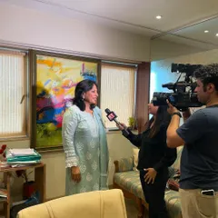 Another angle from the same interview, with the camera crew setting up the shot.