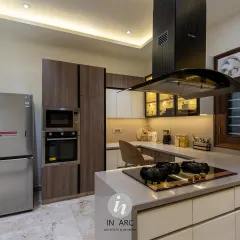 A side view of this modular kitchen, showing the integrated oven and microwave tower next to the double-door refrigerator. The layout is designed for a seamless and efficient workflow.