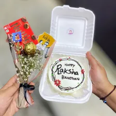 Another angle of our popular Rakhi hamper, showing the hand-piped details on the bento cake and the cute Rakhi-themed tags on the chocolate bouquet.