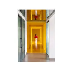 The reflective ceiling in this corridor of 'The Amber Encase' creates a surreal, inverted reflection, adding a layer of artistic abstraction to the functional space.