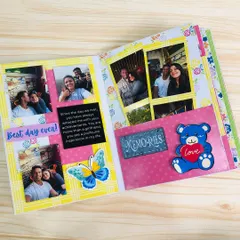 An inside page of the scrapbook, showing a collage of photos, a personal message, and cute embellishments like a teddy bear and butterfly.