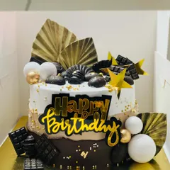 A stunning two-tone chocolate overloaded cake with gold and white accents.