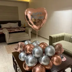 A simple and elegant balloon bouquet for a birthday surprise. The rose gold and silver balloons are perfect for a sophisticated celebration at home.