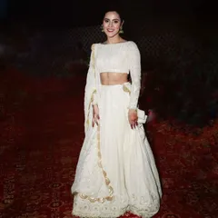 A client looking stunning in a custom white Chikankari lehenga. The full-sleeve blouse and detailed embroidery create a sophisticated and timeless look for any wedding event.