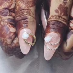 This beautiful bridal set was created by one of our students. They learn to design nails that complement traditional attire and henna, using 3D flowers and delicate chain accents.