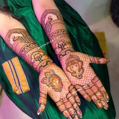 The complete bridal look, with Shreenathji and Ganpati Bappa on the palms and elegant peacocks watching over from the arms. A truly divine and traditional design.