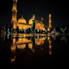 The magnificent Jama Masjid in Delhi, perfectly reflected in a puddle after rain. This night shot captures the grandeur of Mughal architecture with a creative, symmetrical composition.
