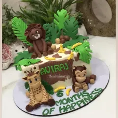 This view shows the personalized name "Aviraj" on the safari-style cake.