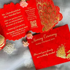 A vibrant and traditional naming ceremony invitation in auspicious red. The card features a beautiful gold foil peacock motif and a unique scalloped, tri-fold design that makes it feel extra special. It also includes a QR code for easy navigation to the venue.