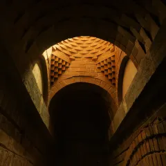 The play of light and shadow within a brick vault at the Samyak Yoga Retreat. The geometric precision of the brickwork creates a dynamic visual effect, turning a simple structural element into a piece of art.