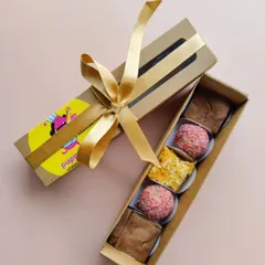 This is my 'Kiara's Chotu Dhamaka Box', a smaller Diwali treat box perfect for a single doggo. It includes a mix of brownies, barfis, and laddoos, beautifully packaged with a ribbon.