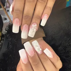 A beautiful example of modern bridal nails. This set features a soft white ombre on a squared nail shape, with intricate 3D floral accents on a few nails for a touch of texture and romance.