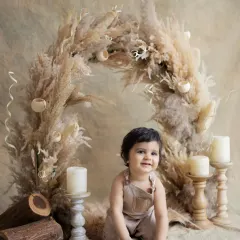 A happy baby in our boho-themed setup. The pampas grass arch and neutral tones create a soft and dreamy backdrop for a sitter session.