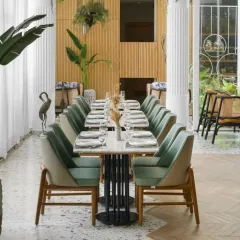 This view of the Elina Vara brasserie showcases my passion for biophilic design. I brought the outdoors in by using natural wood, lush greenery, and a light color palette to create a dining space that feels fresh and serene. The design connects directly to the restaurant's farm-to-fork philosophy, offering guests a tranquil escape in the city.