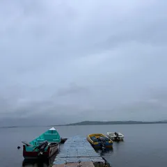 A moody, atmospheric shot of the boats docked at Vani Vilas Sagar on a rainy day, showing the beauty of the location in all weather.