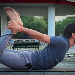 This is Dhanurasana, or Bow Pose, a powerful backbend for improving spinal elasticity. I guide my clients through this pose carefully, as it can be very beneficial for strengthening the back and managing issues like a slipped disc when done correctly.
