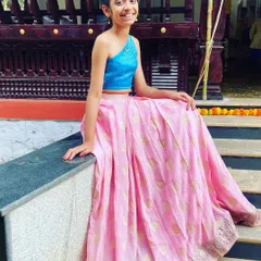 A closer look at this custom Indo-Western lehenga set, showing how the modern one-shoulder top sits beautifully. The combination of the bright blue top and the soft pink skirt makes for a cheerful and eye-catching ensemble.