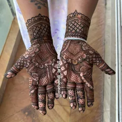 A gorgeous design where the palms are filled with intricate patterns and the fingers are adorned with delicate lotus buds. The wristband features a classic checkerboard pattern.