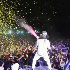 A perfectly timed shot of me firing a confetti gun over the audience, showering them in golden paper as the party hits its peak.