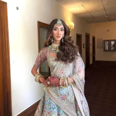 The complete bridal look. The big, glamorous waves are the perfect complement to her ornate, pastel blue lehenga.