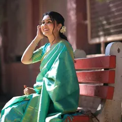 A candid smile that lights up the frame. This close-up shows the fresh makeup and the delicate gajra in her hair, perfect for a traditional ceremony.