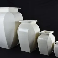A set of elegant, white fiber planters in various sizes. Their classic shape makes them suitable for any decor style.
