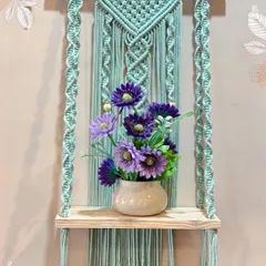 My work is both beautiful and practical. This sturdy macrame wall shelf, shown here with a lovely vase, is perfect for holding small plants, books, or your favorite decorative items.