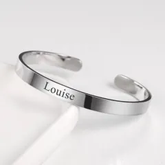 A classic silver-finish metal kada, or bracelet, with a name elegantly engraved on the surface. It's a timeless and personal piece of jewelry.