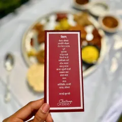 A personalized menu card for a Maharashtrian Pangat, written in Marathi. This small detail adds an authentic and personal touch to the traditional dining experience, listing all the delicious dishes to come.