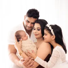 An intimate close up of the family admiring their newest member. These candid style shots capture the genuine emotions and connections during a family newborn session.